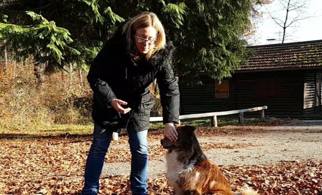 Trainerin Simone Müller hält dem Hund die Augen zu